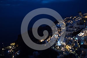 Whitewashed Houses and Windmill on Cliffs with Sea View at Night