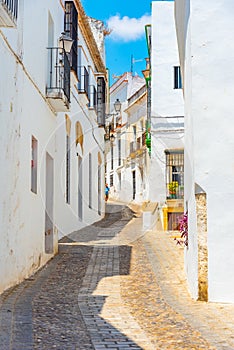 Whitewashed street of the old town of Arcos de la Frontera, one of pueblos blancos, in Spain photo