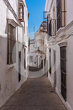 Whitewashed street of the old town of Arcos de la Frontera, one of pueblos blancos, in Spain photo