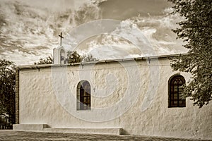 Whitewashed traditional church or hermita in a small village in Spain Sepia photo
