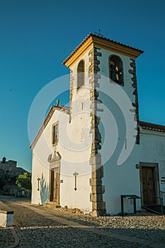 Whitewashed wall in old church with steeple and wooden door