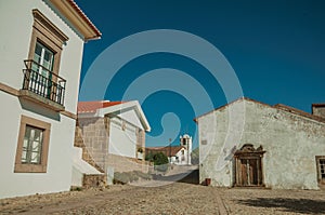 Whitewashed wall in old houses and entrance with stone door frame