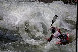 Whitewater kayaker races down stream