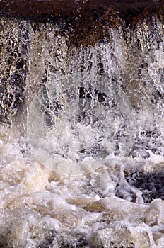 Whitewater waterfall with splashing water drops.