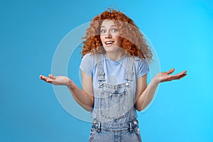 Who knows. Careless clueless attractive playful redhead cute curly-haired girl shrugging unaware hold hands sideways