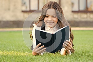 Who needs rest when theres another book to be read. Adorable small child read book on green grass. Cute little girl