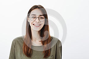 Who says glasses for nerds. Portrait of happy good-looking friendly woman in trendy eyewear, smiling broadly and