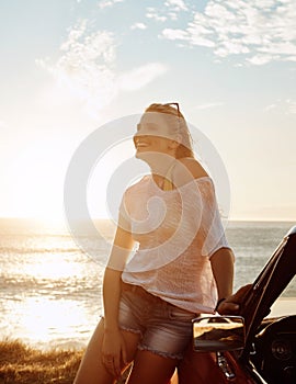 Who wants to be stuck indoors on this kinda day. a happy young woman enjoying a summers road trip.