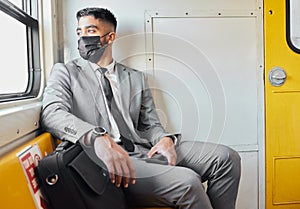 Who wouldve thought that life would be like this. a young businessman wearing a face mask while staring out the window