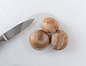 Whole baby bella mushrooms with a knife