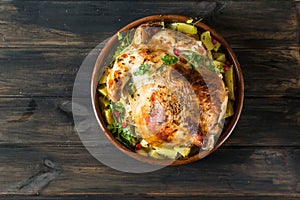 Whole baked chicken with mushrooms and potatoes in a baking dish on a table. Baked turkey. Christmas dish. Easter