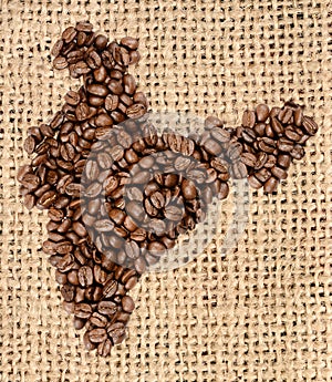 Whole bean coffee. The contour of the India is made of coffee beans on jute burlap
