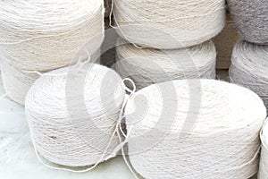 Whole big wheels of natural wool rolls used for the production of woolen socks