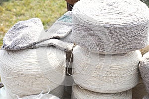 Whole big wheels of natural wool rolls used for the production of woolen socks