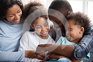 Whole black family sitting together on couch