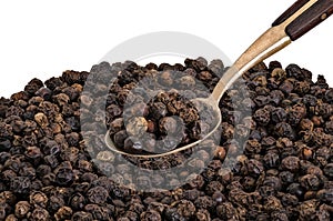 Whole Black Pepper on Old Brass Spoon