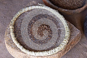 Whole black sage seed on grinding stone