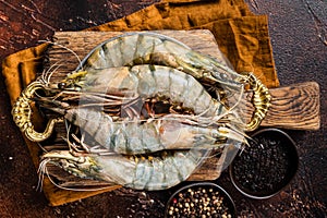 Whole Black tiger giant prawns shrimps in a skillet. Raw Seafood. Dark background. Top view