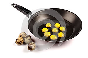 Whole and broken quail eggs in pan