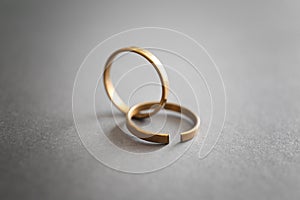 Whole and broken rings on grey background. Concept of divorce