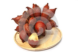 Whole bunch of Salacca zalacca or salak fruit in wooden plate.