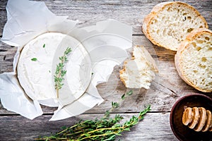 Whole Camembert cheese with thyme, honey and baguette