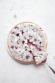 Whole cherry cake with almond petals on white background with cherry flowers