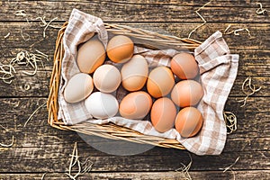 Whole chicken eggs in basket on wooden table. Top view