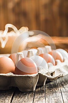 Whole chicken eggs in eggbox on wooden table