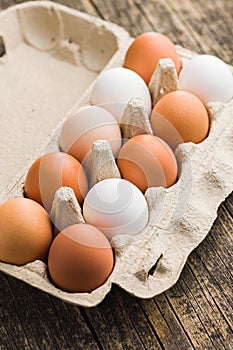 Whole chicken eggs in eggbox on wooden table photo