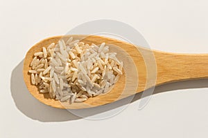 Whole Chinese Rice seed. Nutritious grains on a wooden spoon on