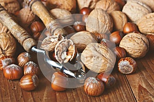 Whole and chopped walnuts  and  nutcracker   on old wooden table