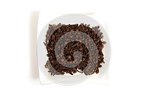Whole cloves in square white bowl