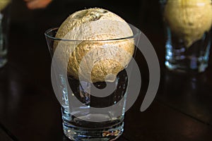 Whole coconut in glass cup