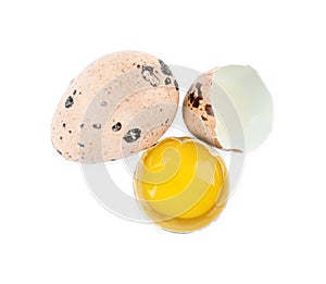 Whole and cracked quail eggs on white background, top view