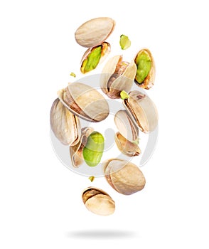 Whole and crushed pistachios close-up in the air on a white background