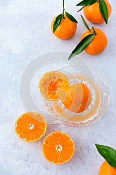 Whole and Cut Clementines with Leaves on Citrus Juicer and Background