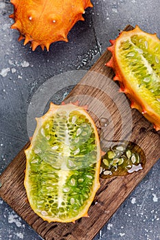 Whole and Cut Kiwano or Horned Melon Exotic Fruit on Board