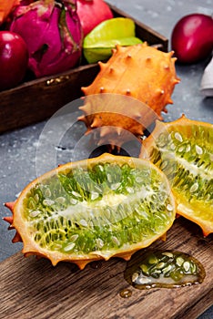 Whole and Cut Kiwano or Horned Melon Exotic Fruit on Board