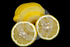 Whole and Cut Lemons on Black Background