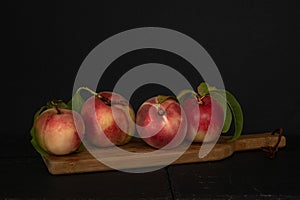 Whole and cut peaches against black