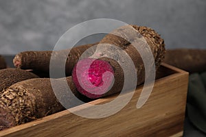 Whole and cut red beets in wooden crate, closeup