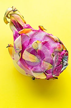 Whole dragon fruit pitaya close-up on yellow background