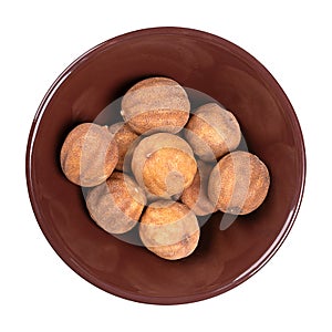 Whole dried limes, sun dried fruits in a brown ceramic bowl
