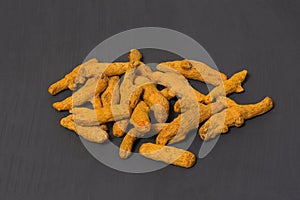Whole dry turmeric root on grey