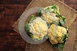 Whole Fresh cauliflower heads on dark wooden background.Top view.