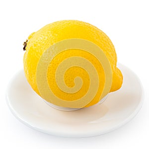 Whole fresh lemon on white plate