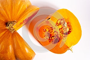 Whole fresh orange big pumpkin and slice of pumpkin on white background, closeup. Organic agricultural product