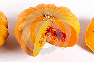 Whole fresh orange big pumpkin and slice of pumpkin on white background, closeup. Organic agricultural product