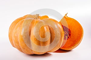 Whole fresh orange big pumpkin and slice of pumpkin on white background, closeup. Organic agricultural product